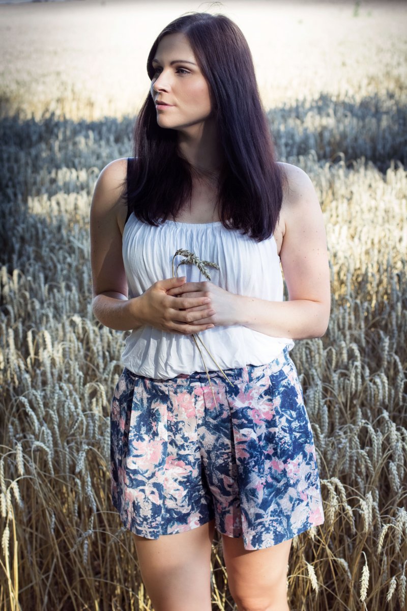 Jessy von Kleidermädchen trägt eine Shorts und ein weißes Top.