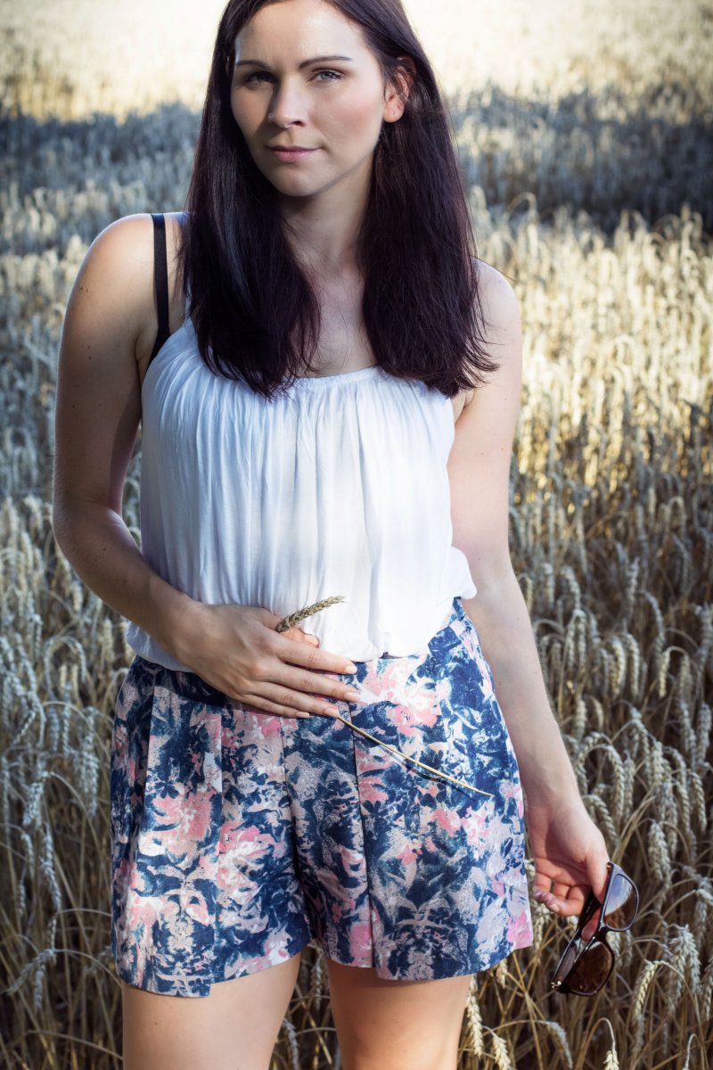 Kleidermädchen trägt ein Sommer Outfit mit Shorts.